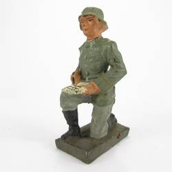 Lineol Signals soldier kneeling, writing